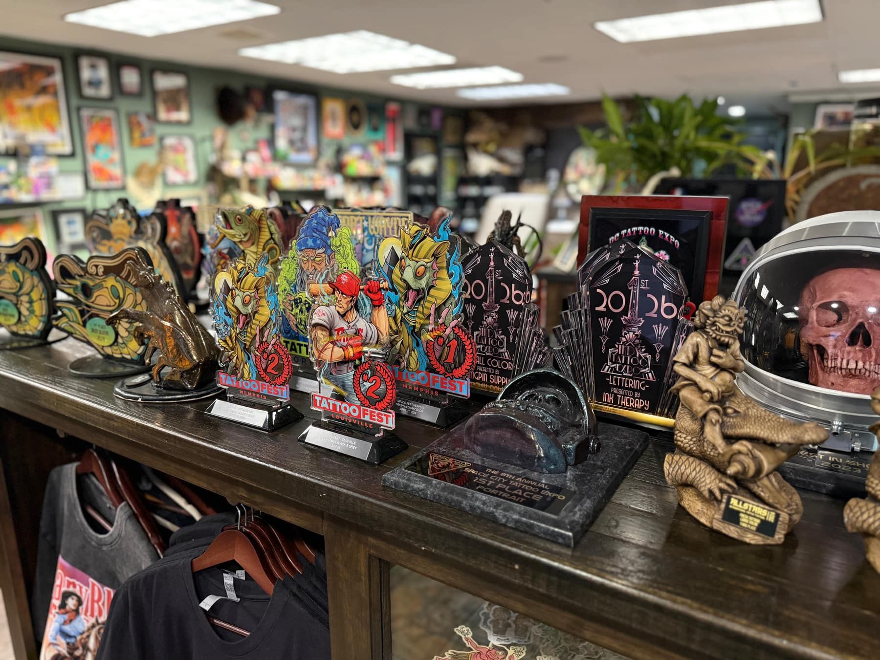 Shelf of tattoo festival trophies and collectible skulls